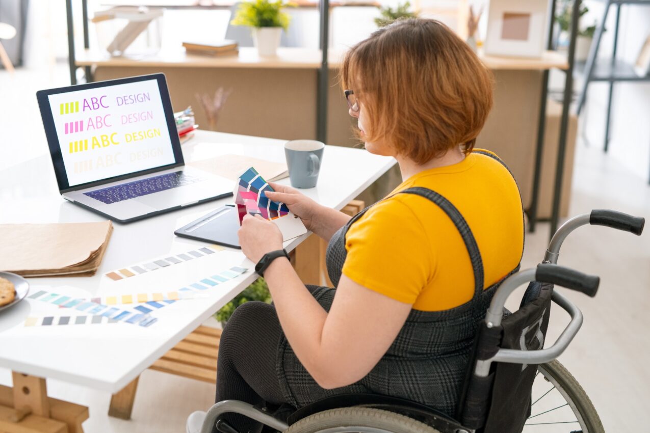 Pretty designer in casualwear choosing color for website design from palette